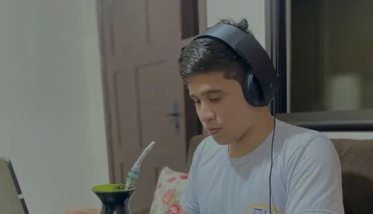 Jakson estudiando con su computadora y un mate